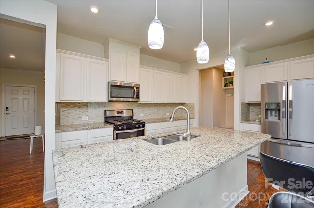 a kitchen with stainless steel appliances granite countertop a sink refrigerator and microwave