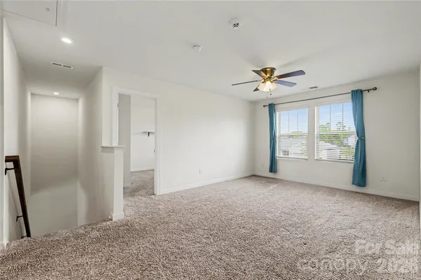 an empty room with fan and windows