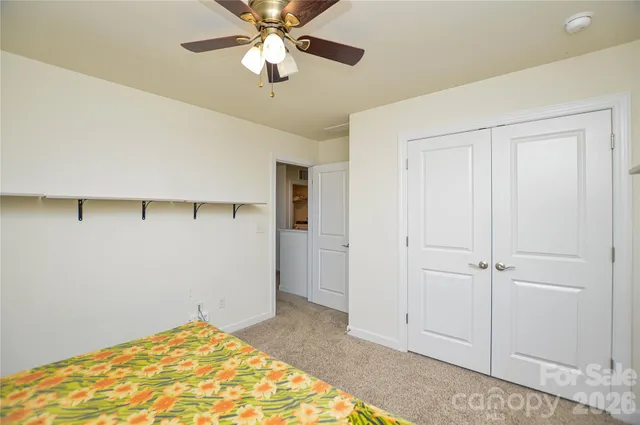 a view of a livingroom with wooden floor and a ceiling fan