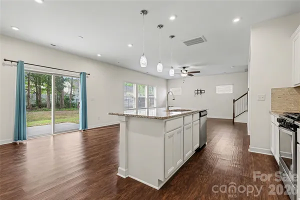 a kitchen with counter top space and wooden floor