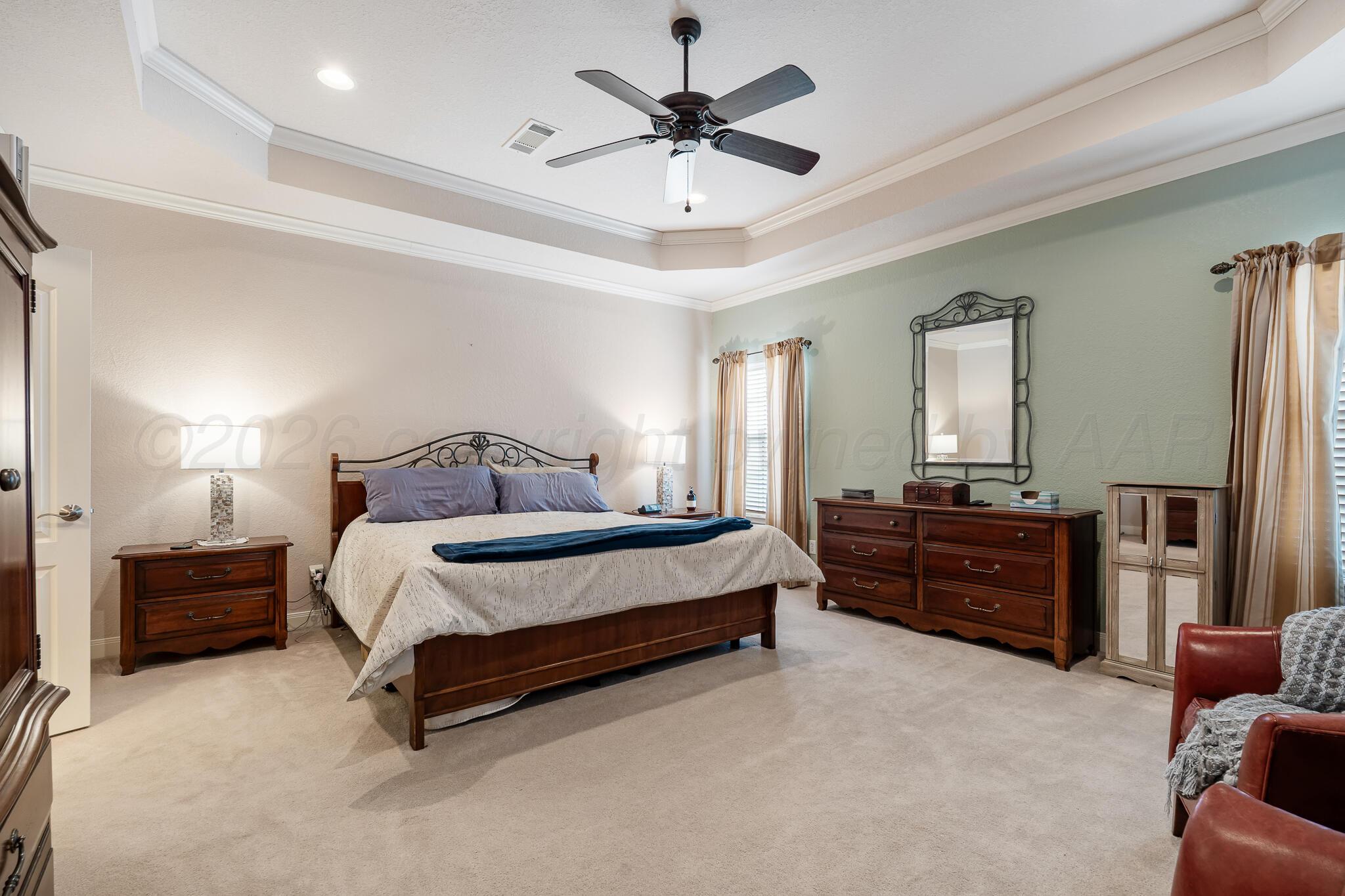 5008 Wesley Road Amarillo, TX 79119 - Photo 21 of 47 a spacious bedroom with a bed and a chandelier