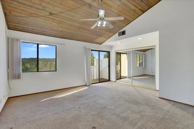 an empty room with a ceiling fan and a window