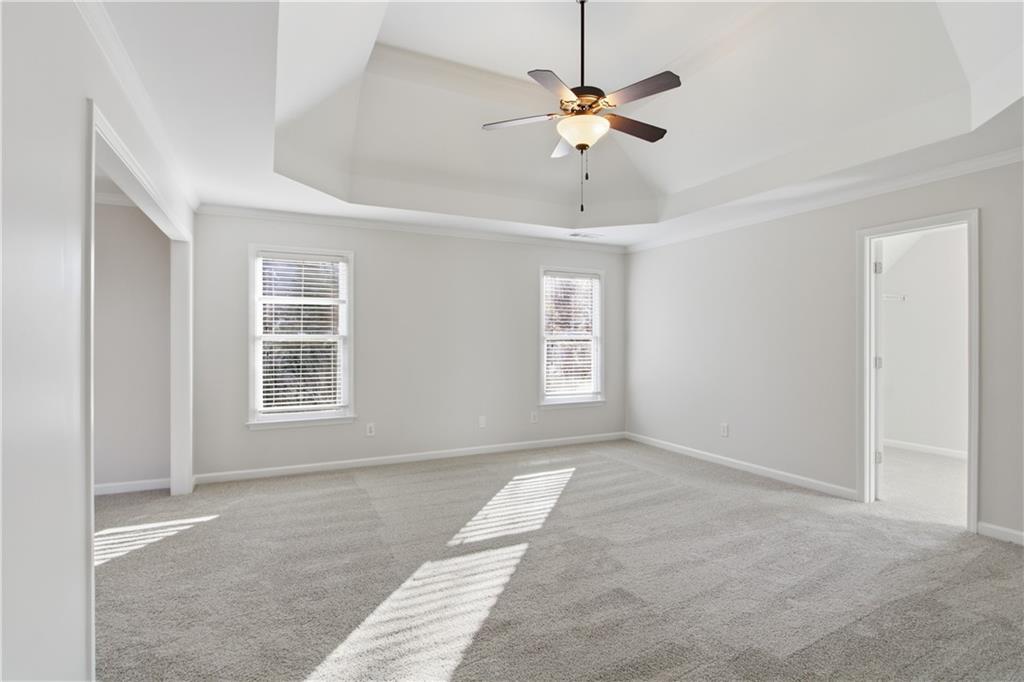 511 Highwater Pass Canton, GA 30114 - Photo 16 of 39 an empty room with a chandelier fan and windows