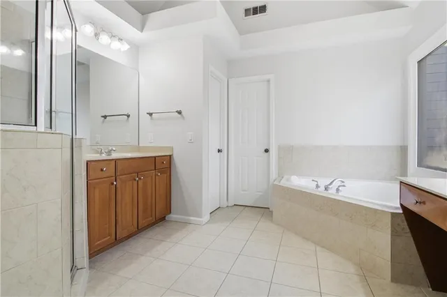 a spacious bathroom with a bathtub sink and mirror
