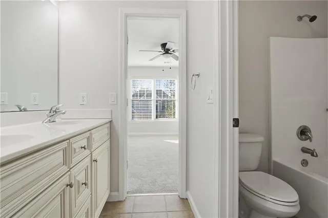 a bathroom with a granite countertop sink toilet a shower and a mirror