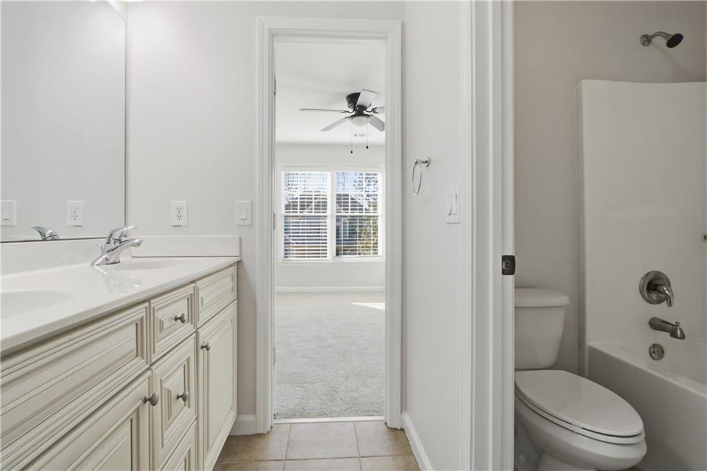 511 Highwater Pass Canton, GA 30114 - Photo 29 of 39 a bathroom with a granite countertop sink toilet a shower and a mirror
