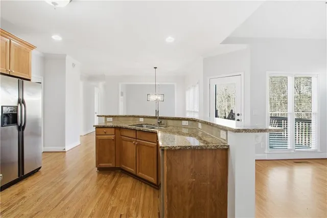 a large kitchen with stainless steel appliances granite countertop a sink and a refrigerator