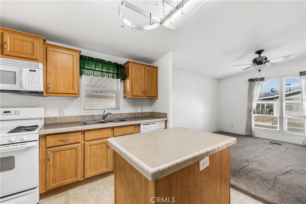 600 South Dennison, Unit 109 Tehachapi, CA 93561 - Photo 15 of 43 a kitchen with a stove a sink a microwave and cabinets