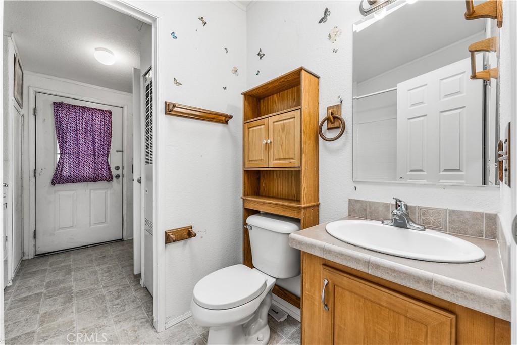 600 South Dennison, Unit 109 Tehachapi, CA 93561 - Photo 27 of 43 a bathroom with a granite countertop toilet sink and mirror