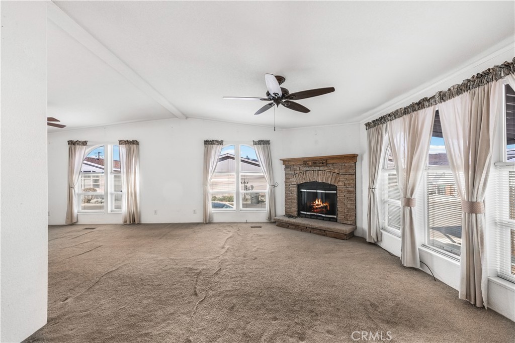 600 South Dennison, Unit 109 Tehachapi, CA 93561 - Photo 5 of 43 a view of a livingroom with a fireplace a ceiling fan and windows