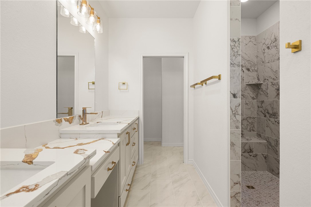 6512 Agave Court Bryan, TX 77808 - Photo 31 of 42 Full bath featuring double vanity, walk in shower, and light marble finish floors
