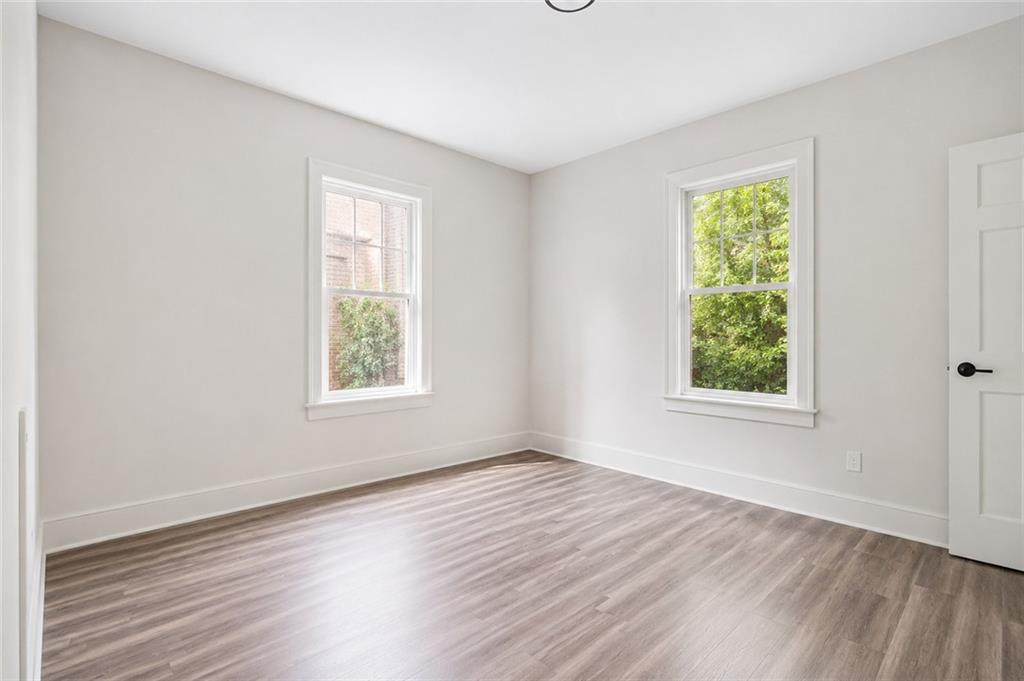 665 Lexington Avenue Southwest Atlanta, GA 30310 - Photo 16 of 33 an empty room with wooden floor and windows
