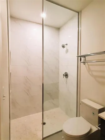 a bathroom with a toilet and a shower