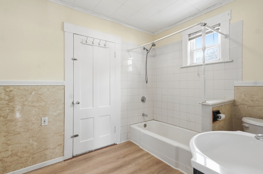 223 School Street, Unit 1 Lowell, MA 01854 - Photo 15 of 21 a bathroom with a bathtub a toilet and a shower