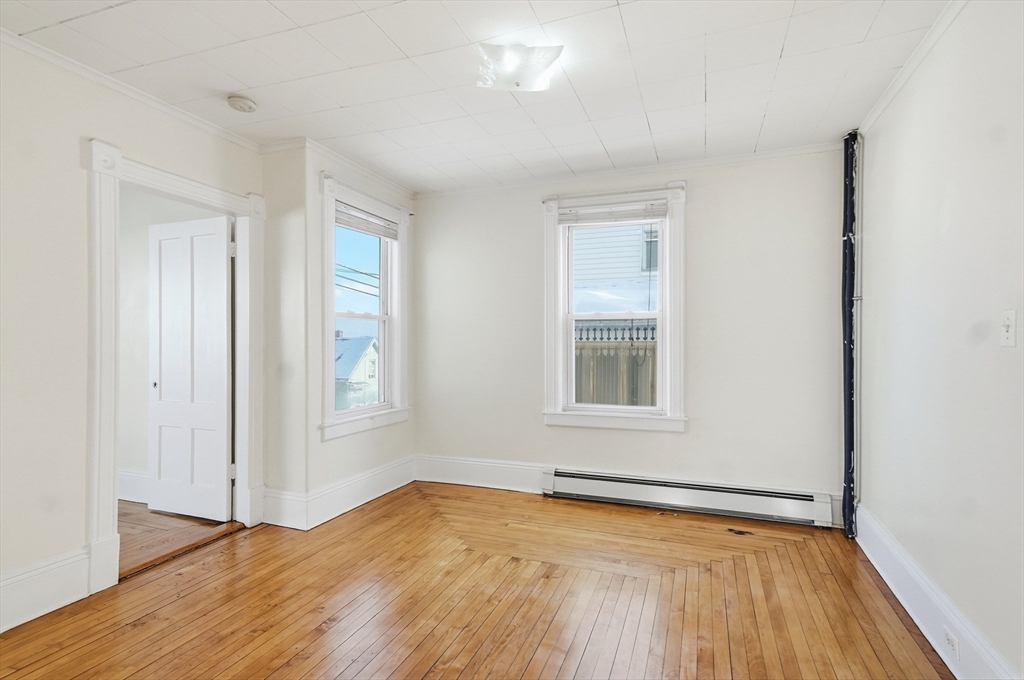 223 School Street, Unit 1 Lowell, MA 01854 - Photo 7 of 21 an empty room with wooden floor and windows