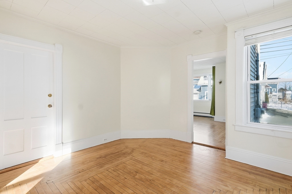 223 School Street, Unit 1 Lowell, MA 01854 - Photo 8 of 21 a view of empty room with wooden floor and fan