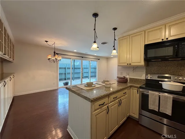 a view of a hallway with wooden floor and a kitchen