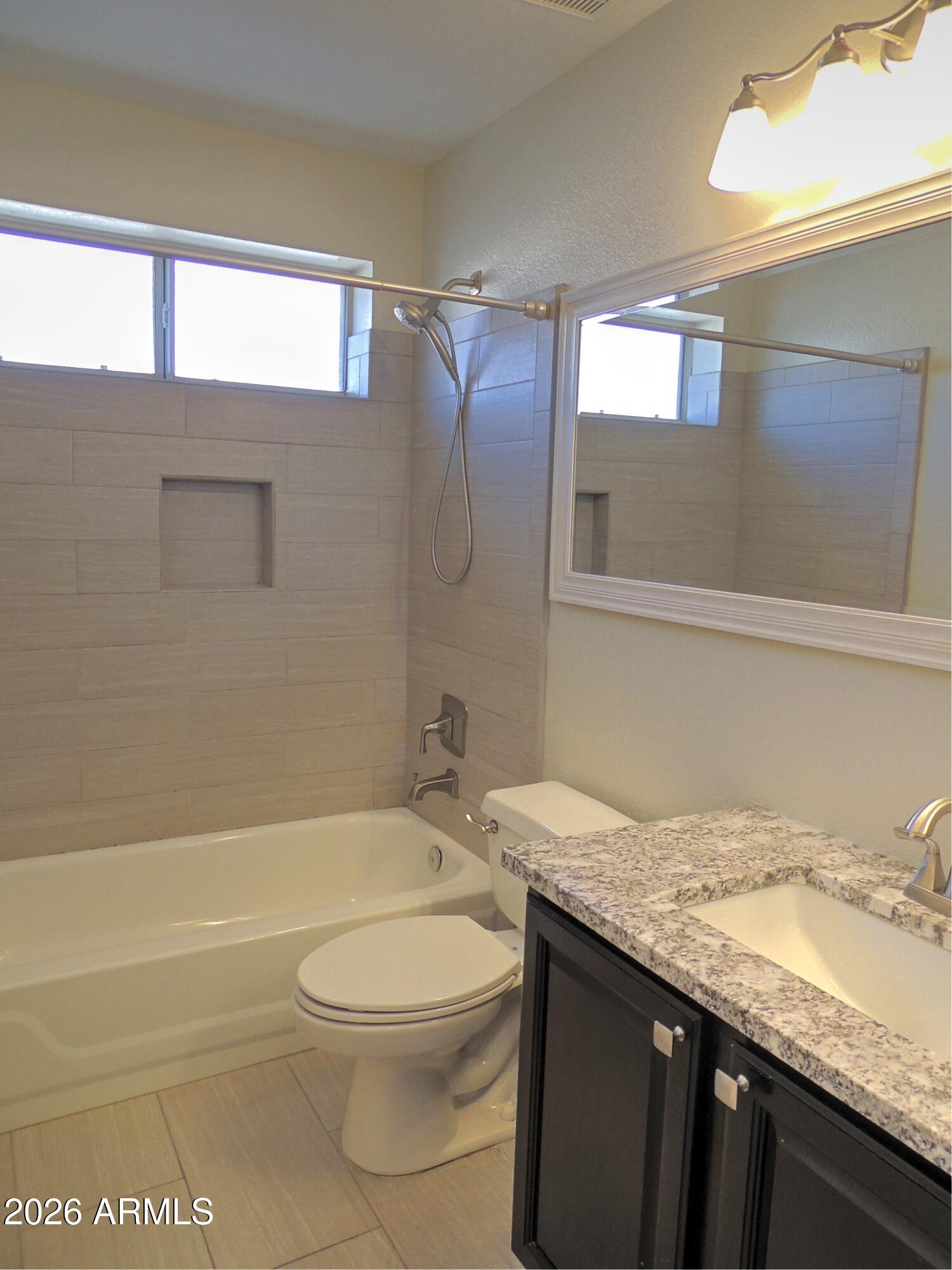 4409 East Dry Creek Road Phoenix, AZ 85044 - Photo 23 of 34 a bathroom with a granite countertop sink a toilet and bathtub