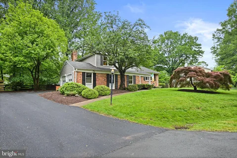 a front view of a house with a garden and yard