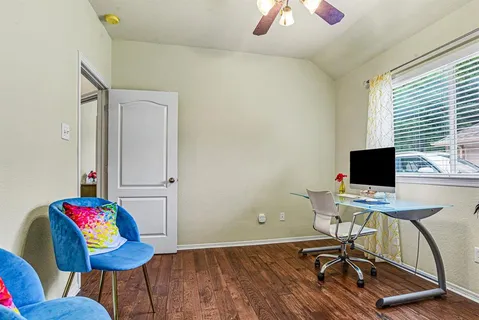 a view of a workspace with furniture and a window