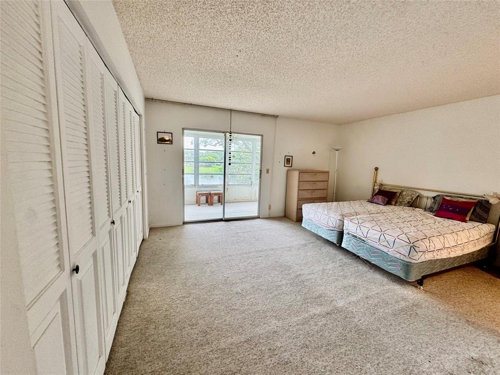 2029 Cambridge B, Unit 2029 Deerfield Beach, FL 33442 - Photo 15 of 36 a bedroom with a large bed and a couch