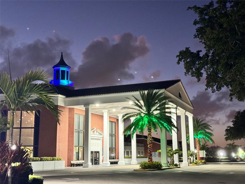 2029 Cambridge B, Unit 2029 Deerfield Beach, FL 33442 - Photo 29 of 36 a front view of a house with a yard glass windows and potted plants