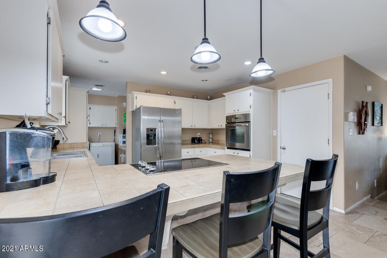 4215 West Dailey Street Phoenix, AZ 85053 - Photo 11 of 32 a kitchen with kitchen island a dining table and chairs