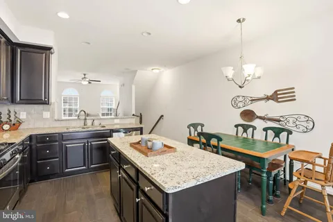 a kitchen with a sink a stove and chairs