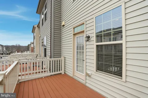 a view of a balcony with wooden floor and fence