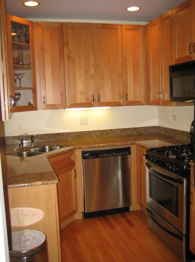 Undisclosed Address Chicago, IL 60613 - Photo 2 of 6 a kitchen with granite countertop wooden cabinets and a stove top oven
