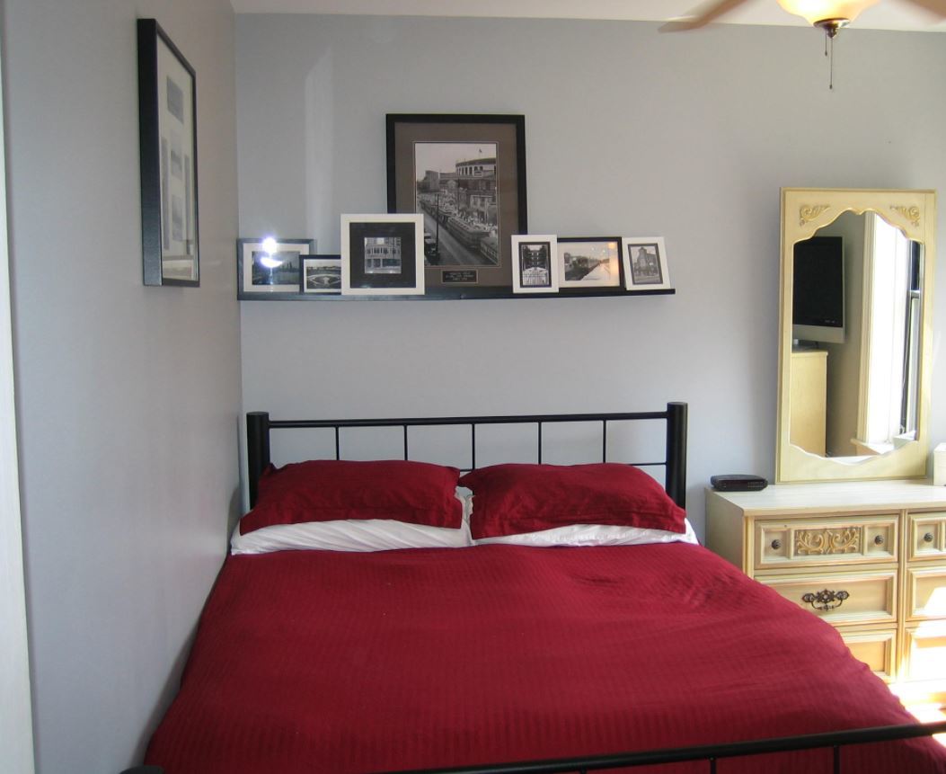 Undisclosed Address Chicago, IL 60613 - Photo 4 of 6 a bed sitting in a bedroom next to a window with potted plants on dresser and a table