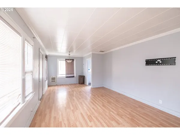 a big room with wooden floor and windows