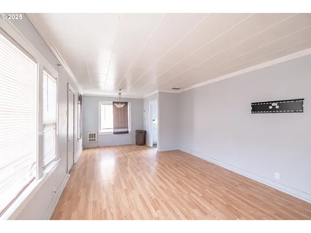 a big room with wooden floor and windows