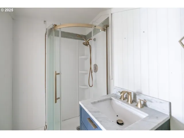 a bathroom with a sink vanity granite tub shower and mirror