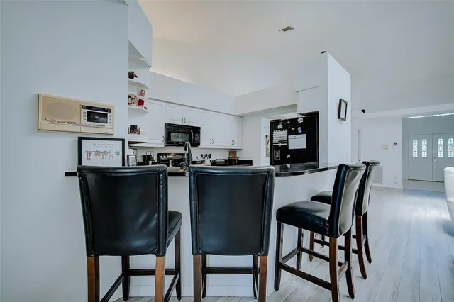 a kitchen with a table chairs microwave and cabinets