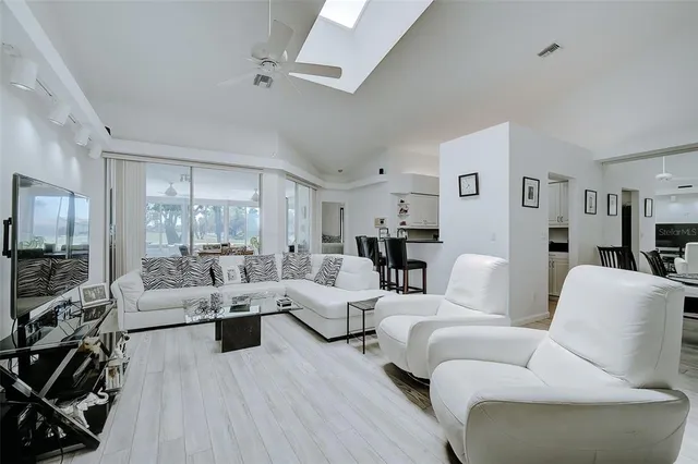 a living room with furniture and a large mirror with wooden floor