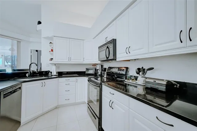 a kitchen with stainless steel appliances granite countertop white cabinets sink and dishwasher