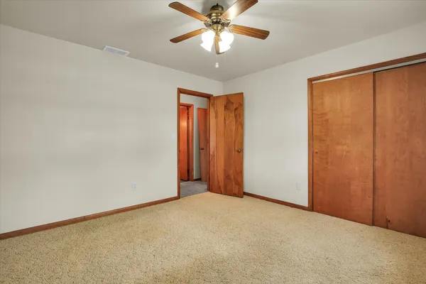 an empty room with closet and windows
