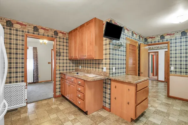 a view of kitchen with stainless steel appliances wooden floor and large windows