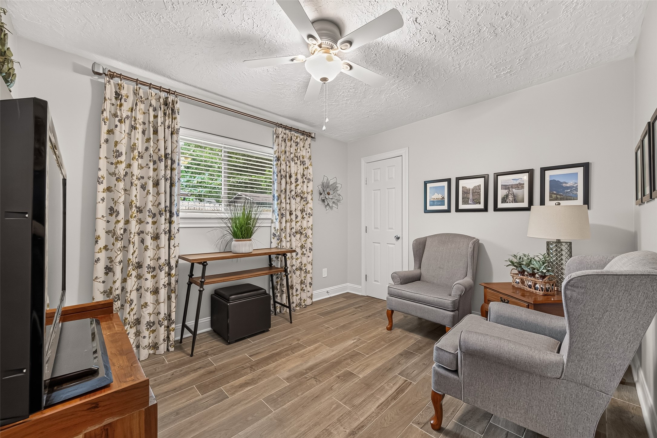 24719 Wilderness Road Spring, TX 77380 - Photo 19 of 42 Charming room with wood-look tile flooring, neutral walls, and a ceiling fan. Ideal for a bedroom or home office.