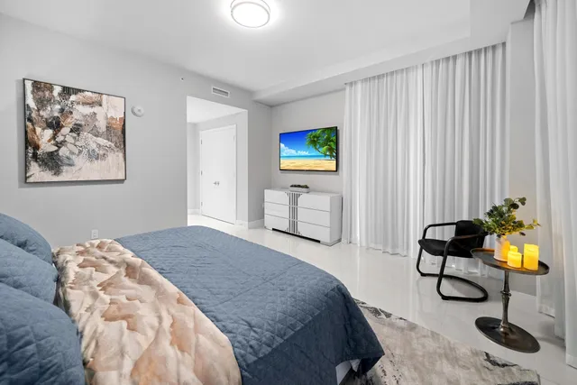 a living room with furniture a flat screen tv and a large window