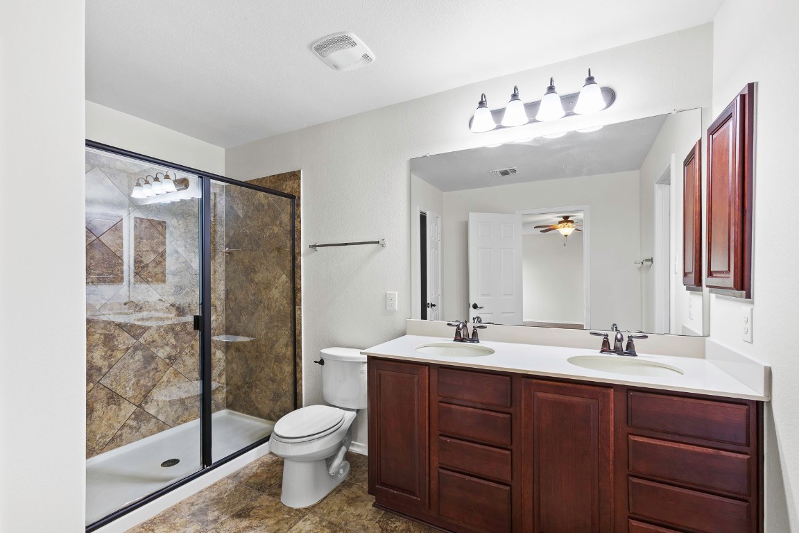 11412 Barns Trail Austin, TX 78754 - Photo 10 of 20 Full bathroom featuring double vanity, a shower stall, and ceiling fan