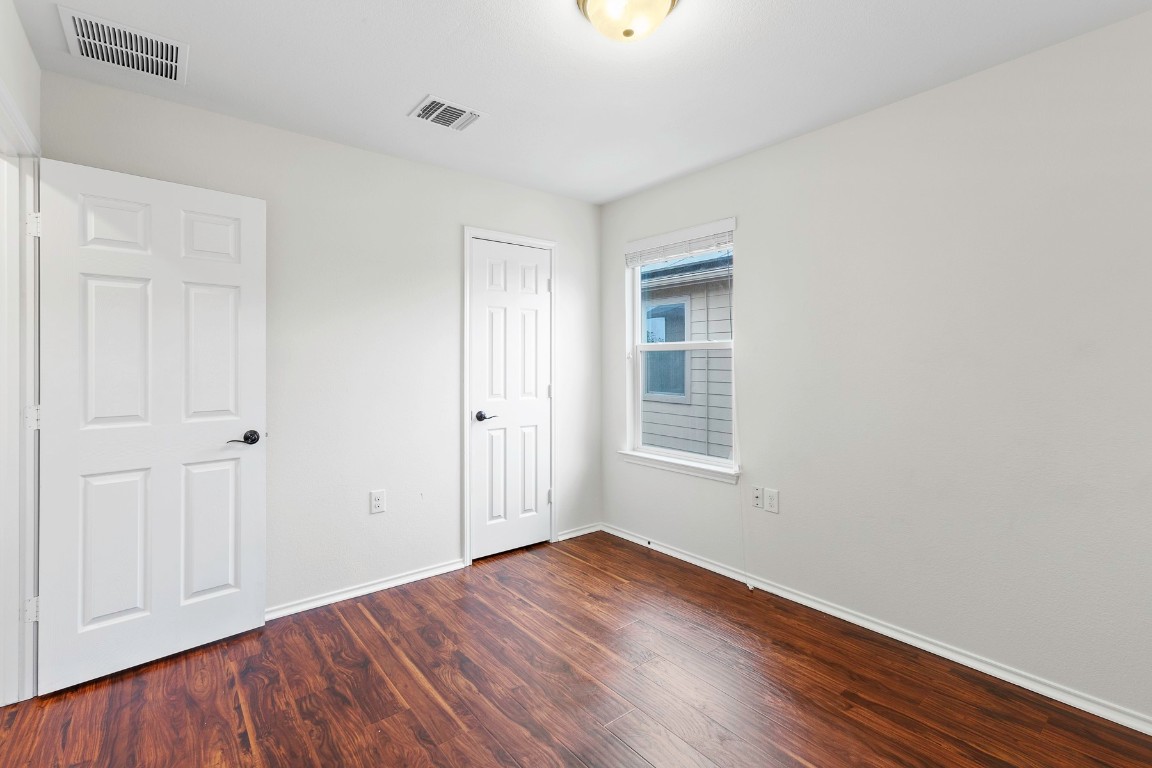 11412 Barns Trail Austin, TX 78754 - Photo 12 of 20 Unfurnished bedroom featuring dark wood-style floors and a closet