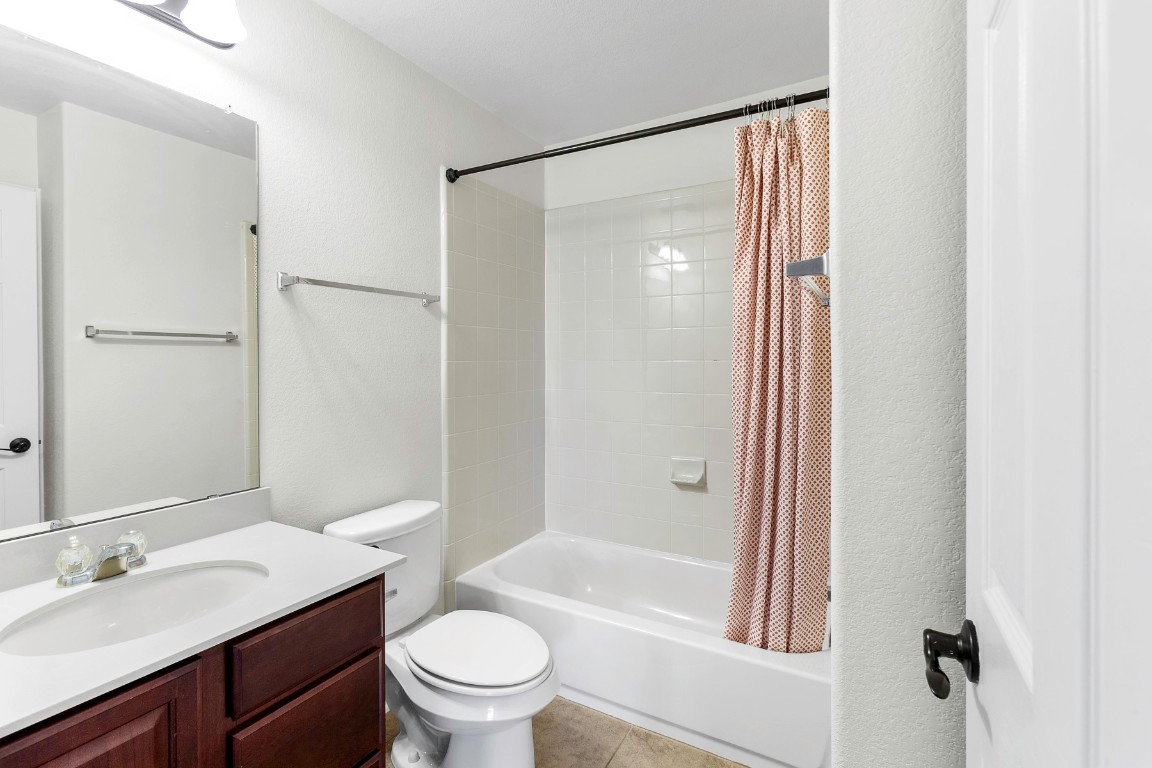 11412 Barns Trail Austin, TX 78754 - Photo 13 of 20 Full bathroom featuring shower / tub combo, vanity, a textured wall, and light tile patterned floors