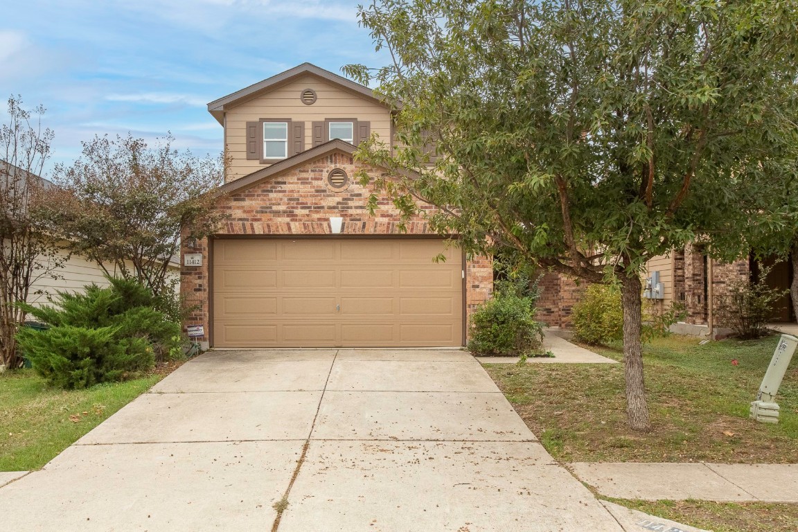 11412 Barns Trail Austin, TX 78754 - Photo 3 of 20 View of front of home with brick siding, concrete driveway, and a garage