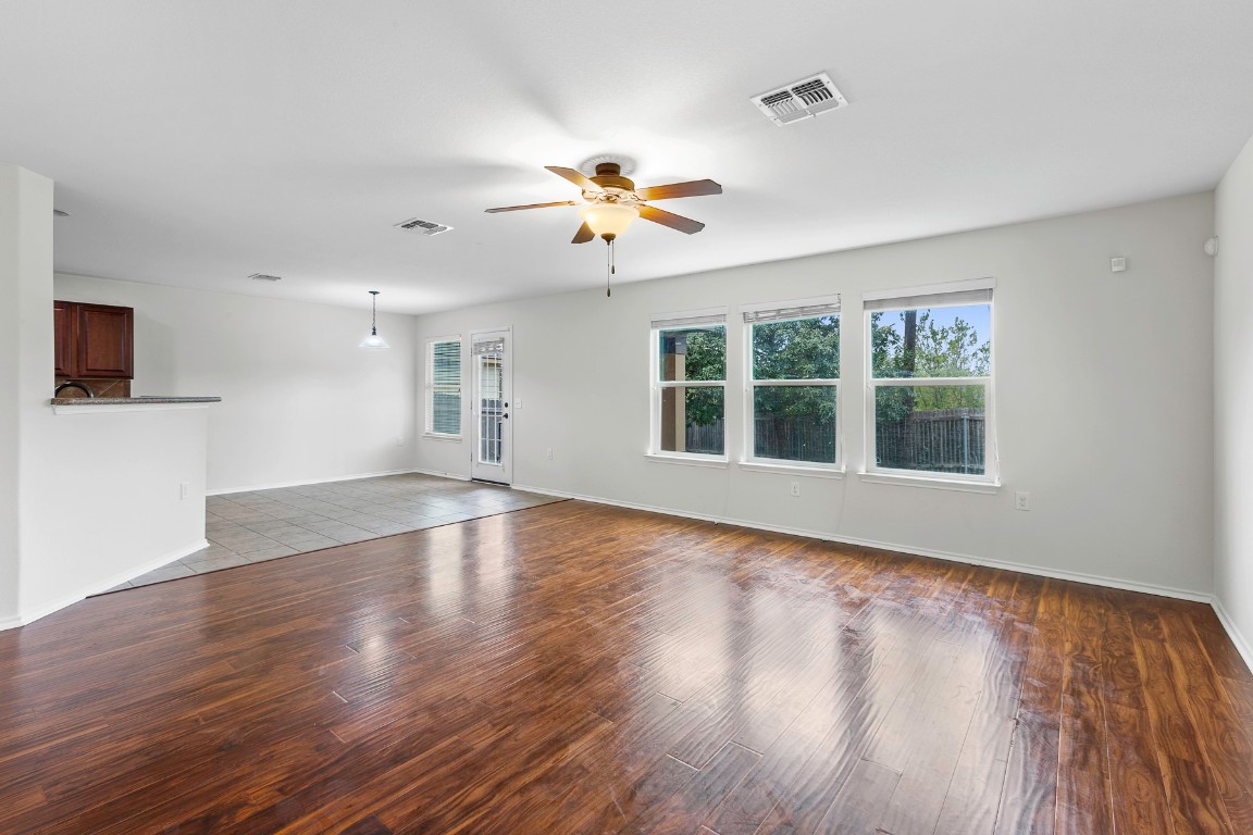 11412 Barns Trail Austin, TX 78754 - Photo 4 of 20 Unfurnished living room featuring a ceiling fan and dark wood-style flooring