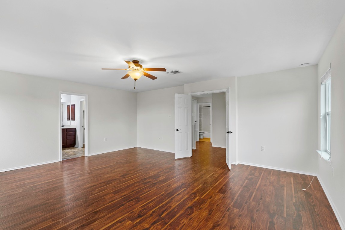 11412 Barns Trail Austin, TX 78754 - Photo 9 of 20 Empty room featuring dark wood-style floors and ceiling fan