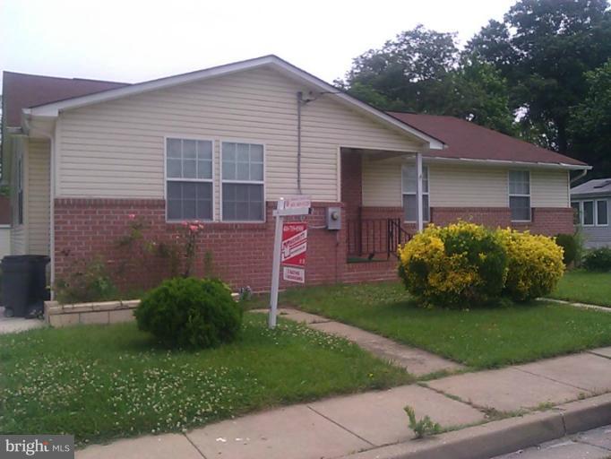 7206 Orth Road Sparrows Point, MD 21219 - Photo 1 of 1 a front view of a house with a garden and yard