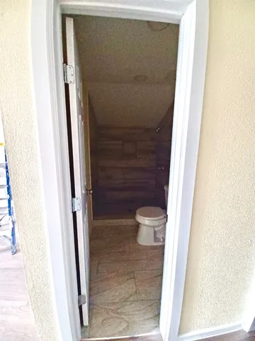 a bathroom with a toilet and a shower