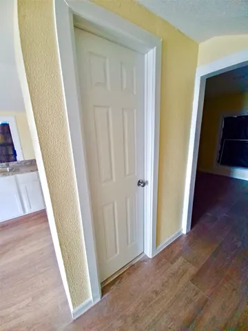 a view of a hallway with wooden floor and staircase